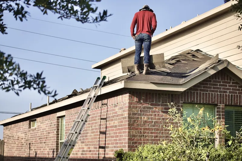 Professional roofer working on a residential roof in Plain